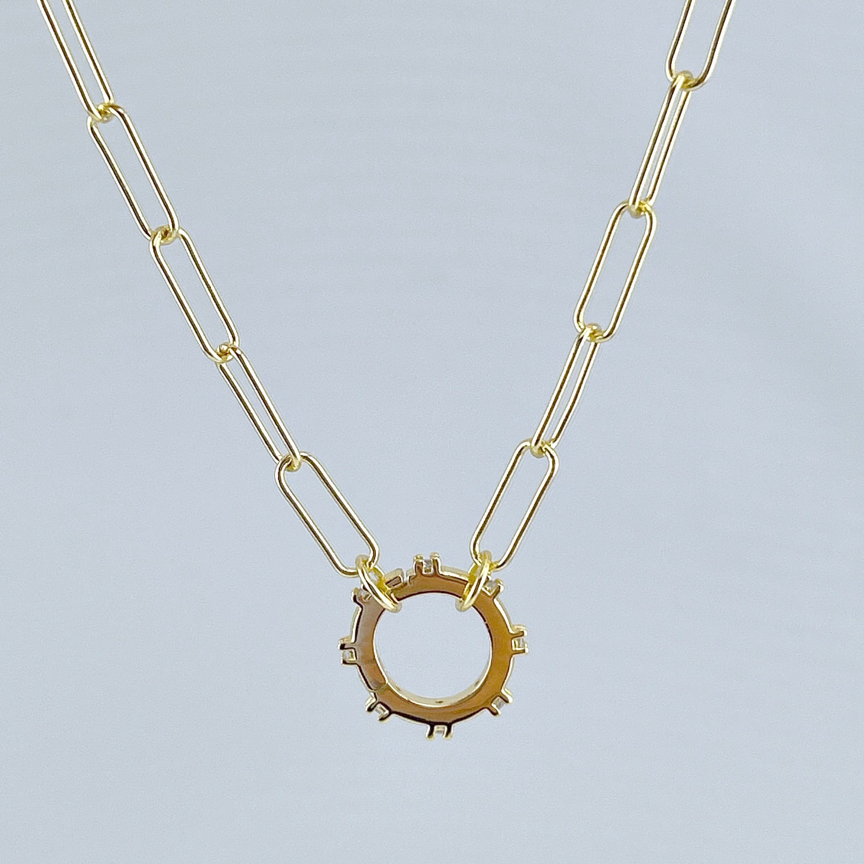  picture of a gold paper clip chain style necklace with a circle connector at the center