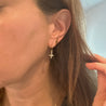 image of side of a girls face showing her ear lobe and wearing one of the cross earrings