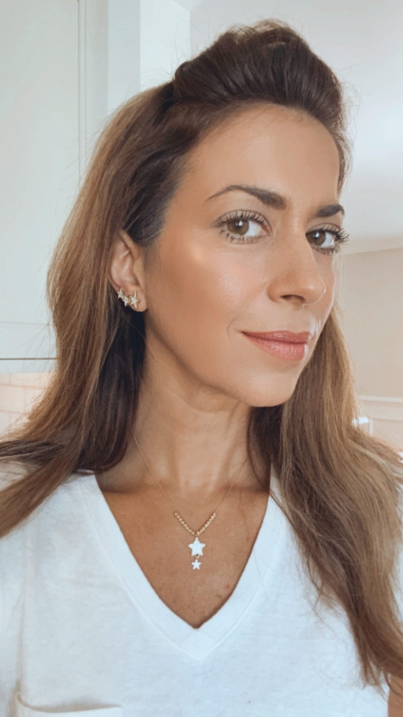 girl wearing a white t shirt and the star necklace along with star climber earrings